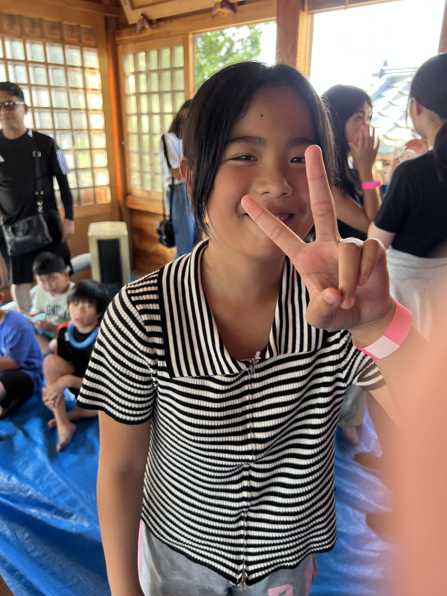 腕相撲大会を前に笑顔でピースする女の子