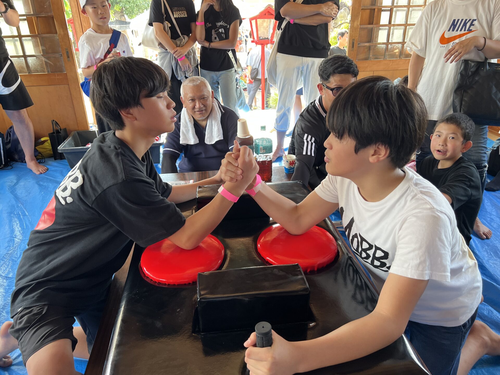 腕相撲で真剣勝負をする二人の男の子決勝戦（福岡市夏祭り）」