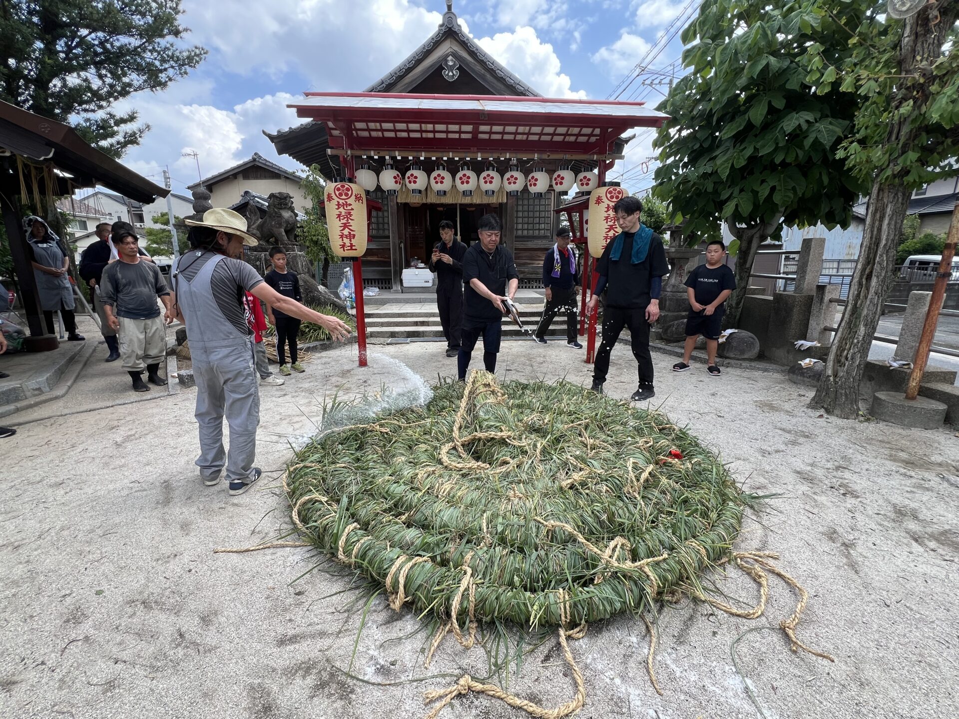 完成した大綱にお神酒を捧げ清める様子（地禄天神社）