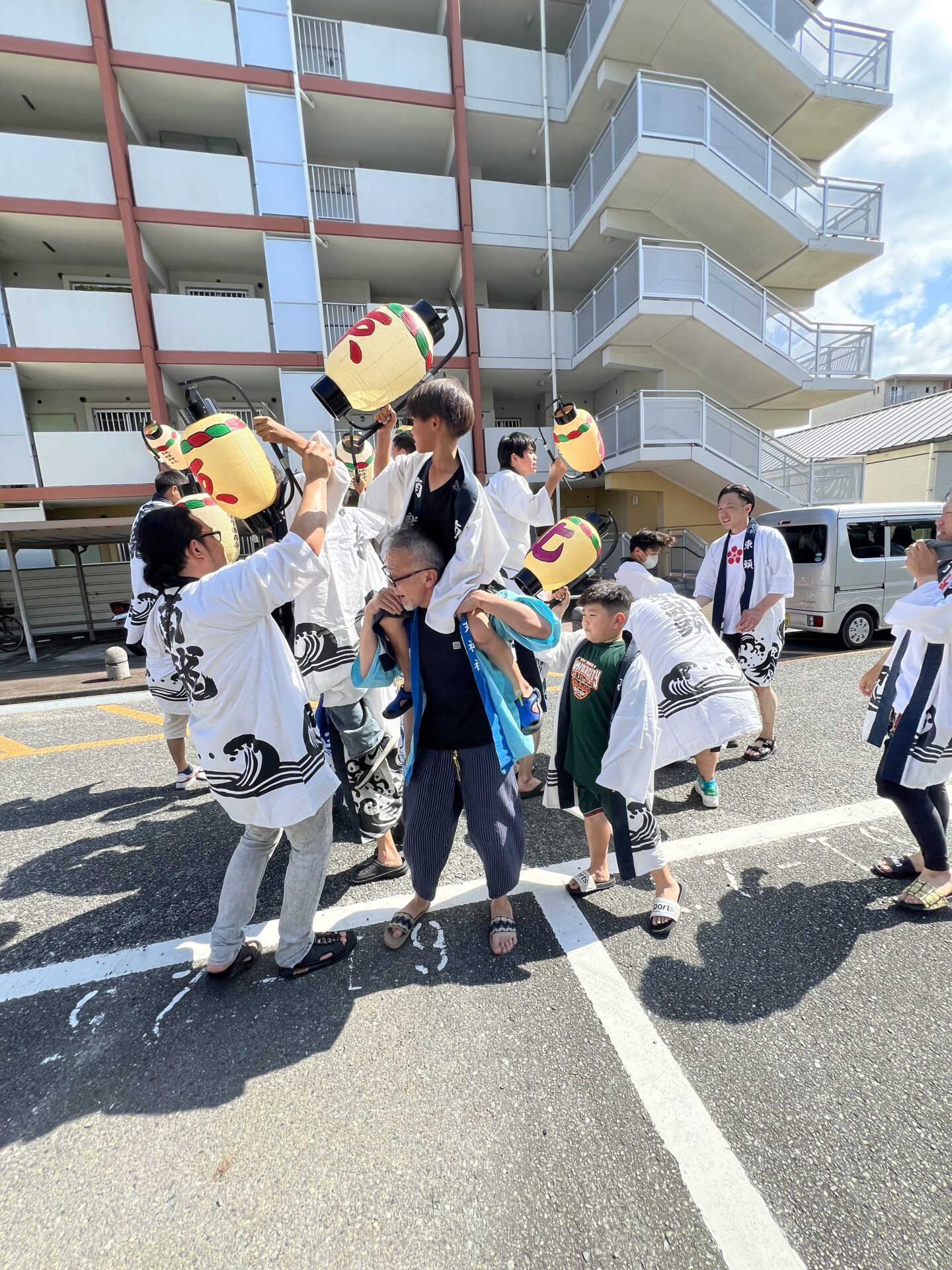 肩車で高く掲げられた提灯、行事の始まりを告げる光景