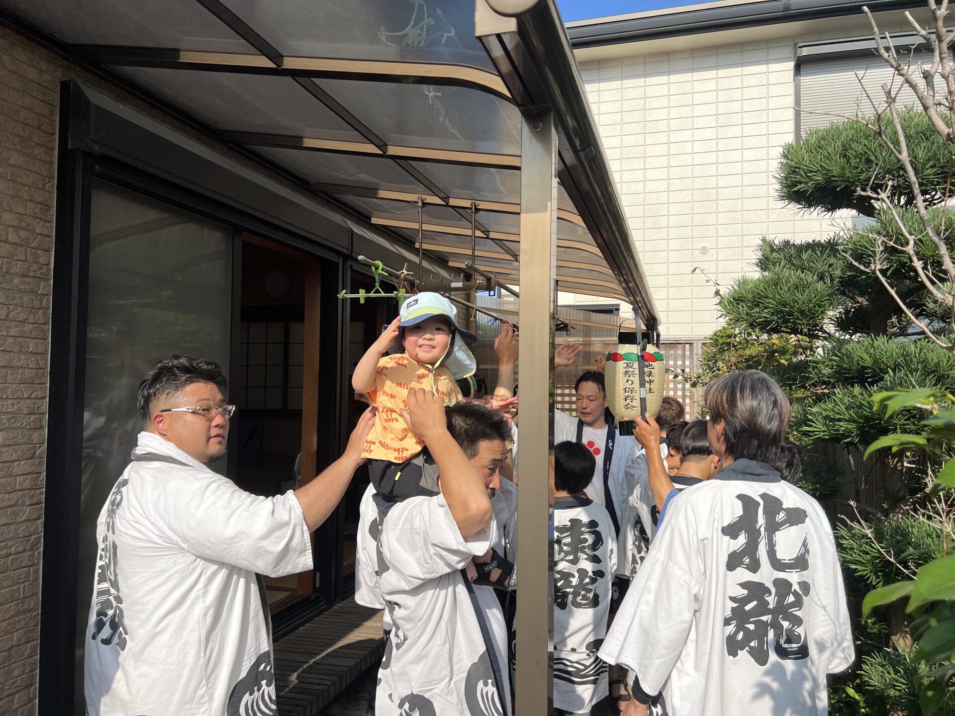 幼い子を囲む青年部。みんなで手をつなぎ見守る