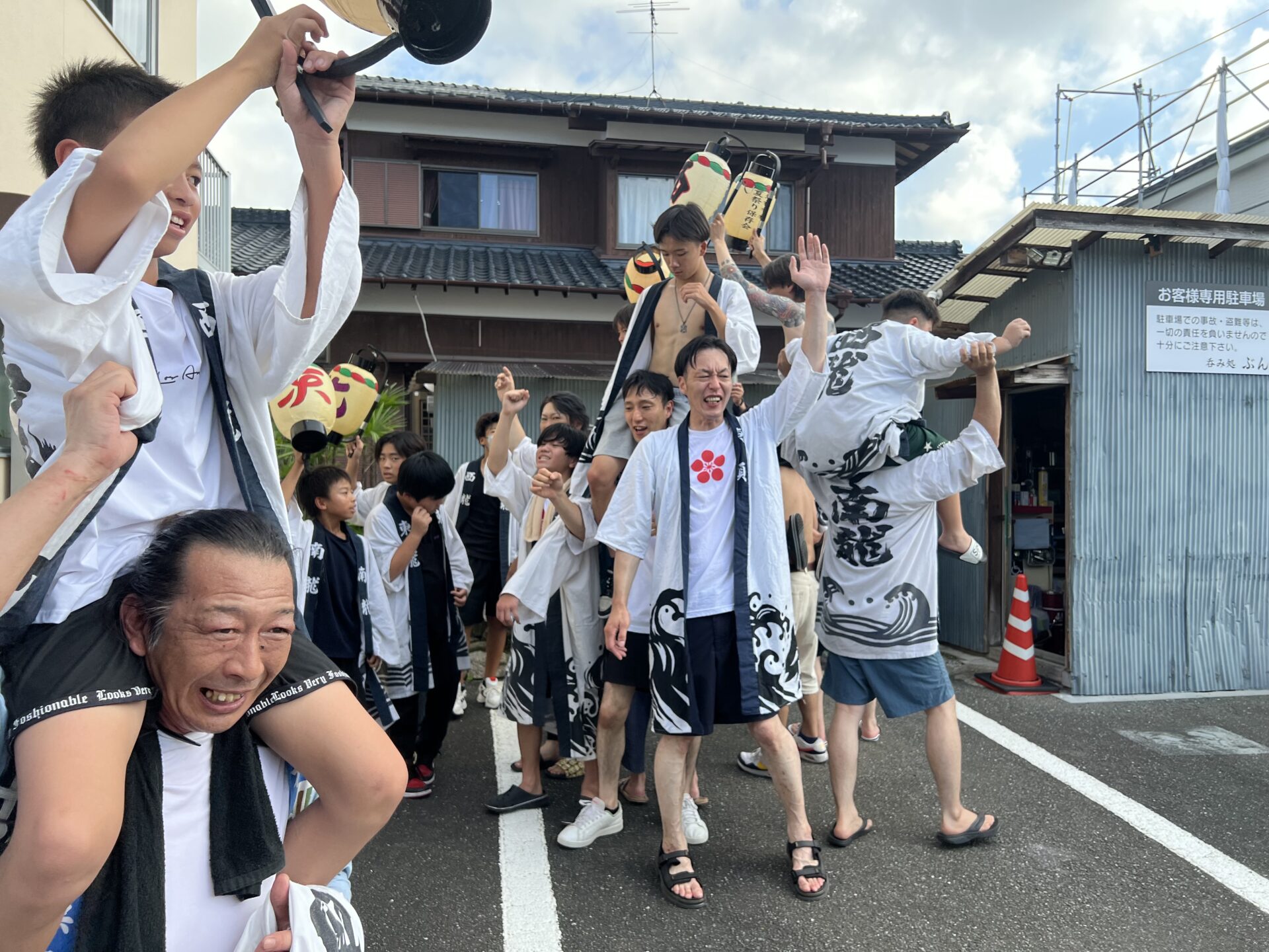 故人ゆかりの家の前で肩車、提灯を高く掲げる瞬間