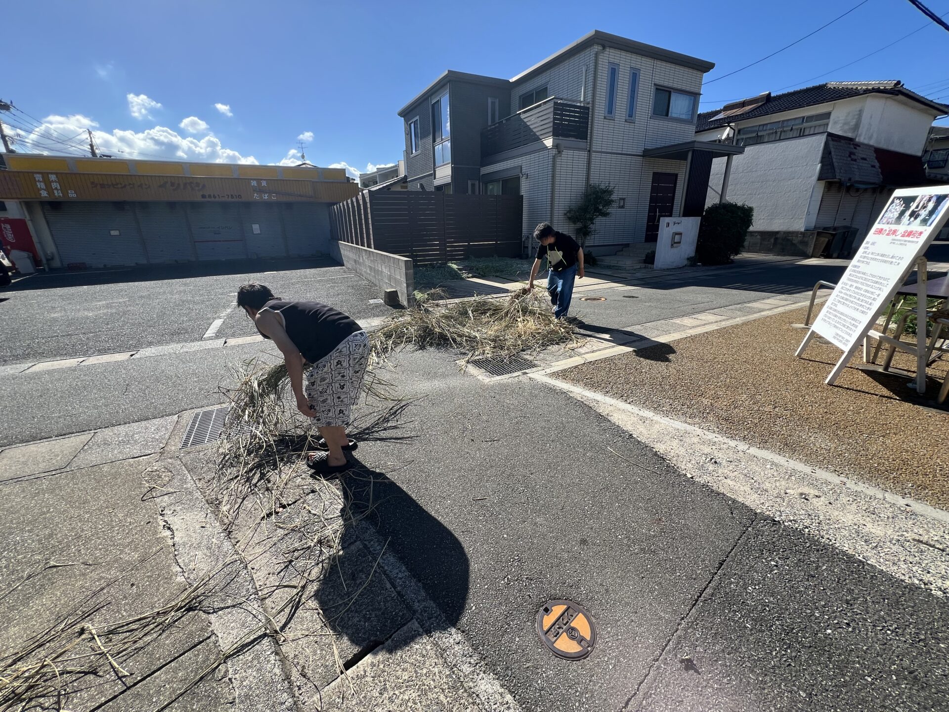 道路に茅を撒き清める準備の様子（早良区・地禄天神社周辺）