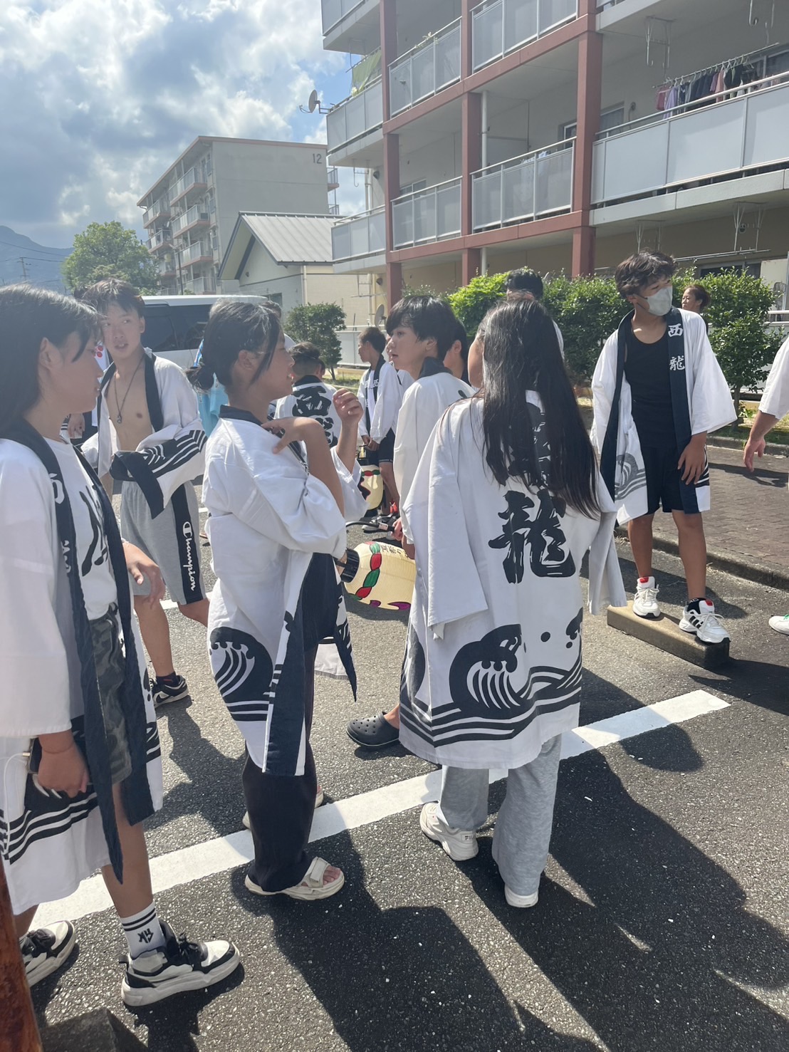 参拝後、庭先で語らう若者たち。笑顔と涙の余韻