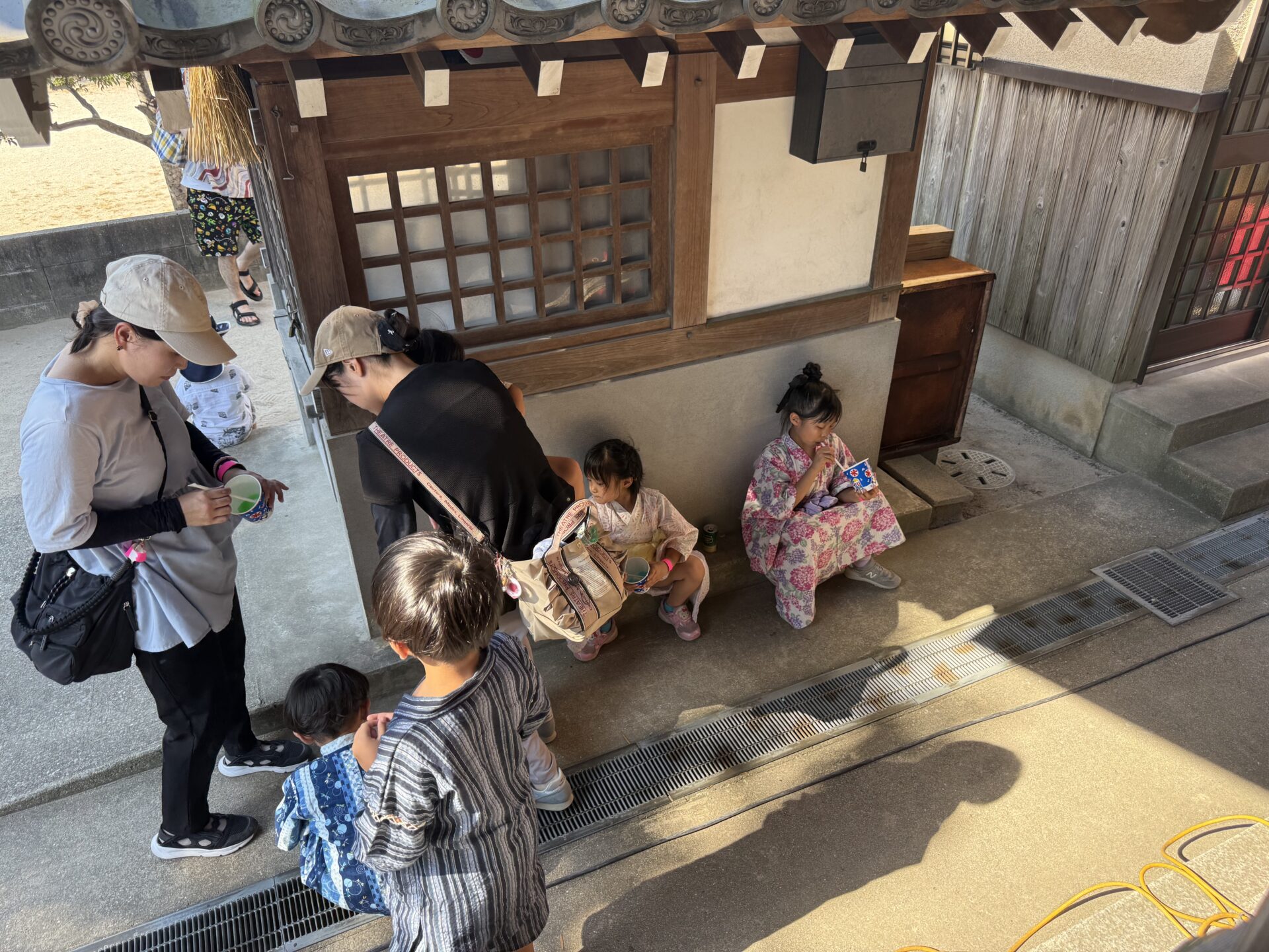 地録天神社でお菓子を楽しむ子どもたちと家族