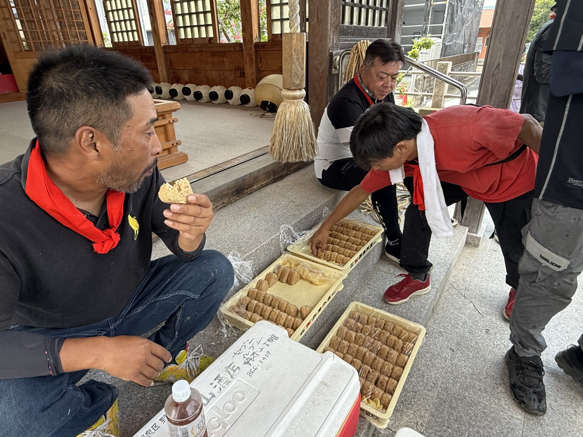 婦人部手作りのかしわおにぎりを食べて休憩する様子