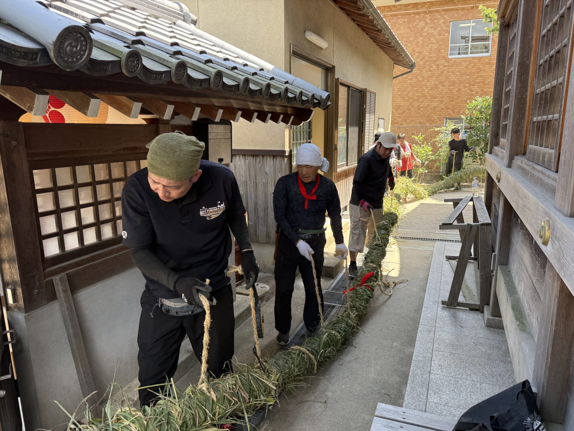 神社脇から盆綱を境内へ運び出す様子