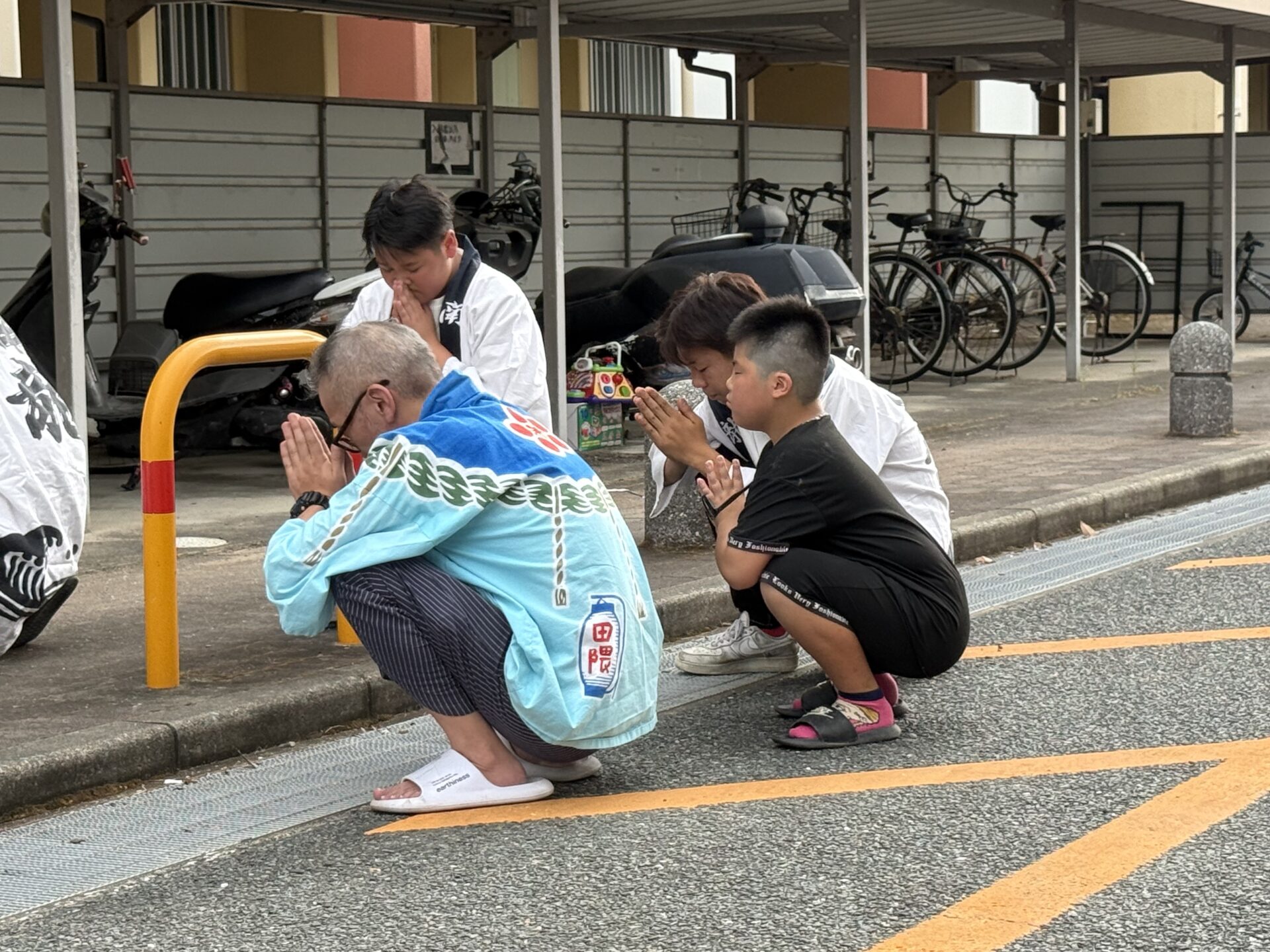 世話役と子どもも一緒に故人へ手を合わせる様子