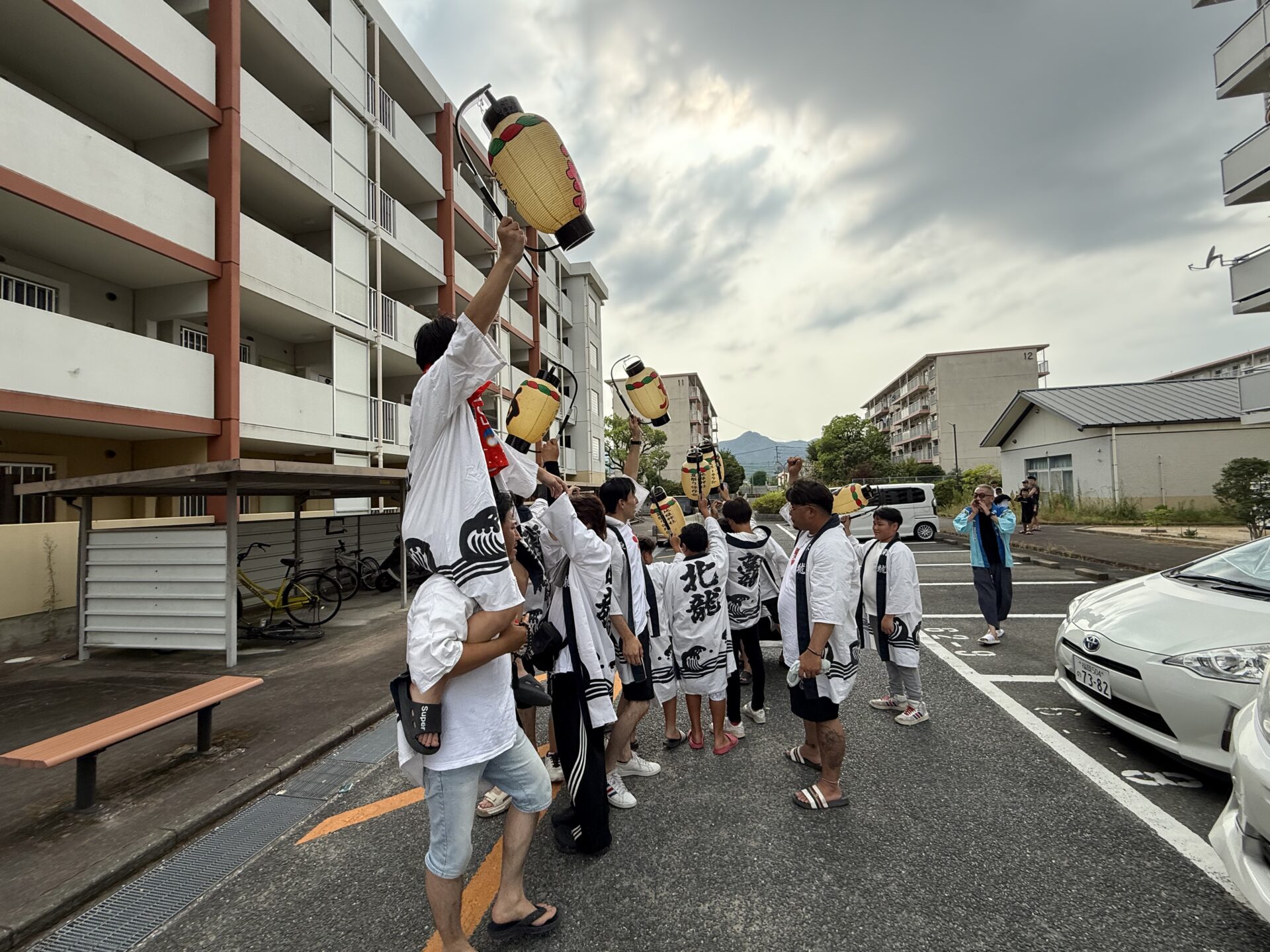 団地で提灯を掲げる初盆参りの参加者