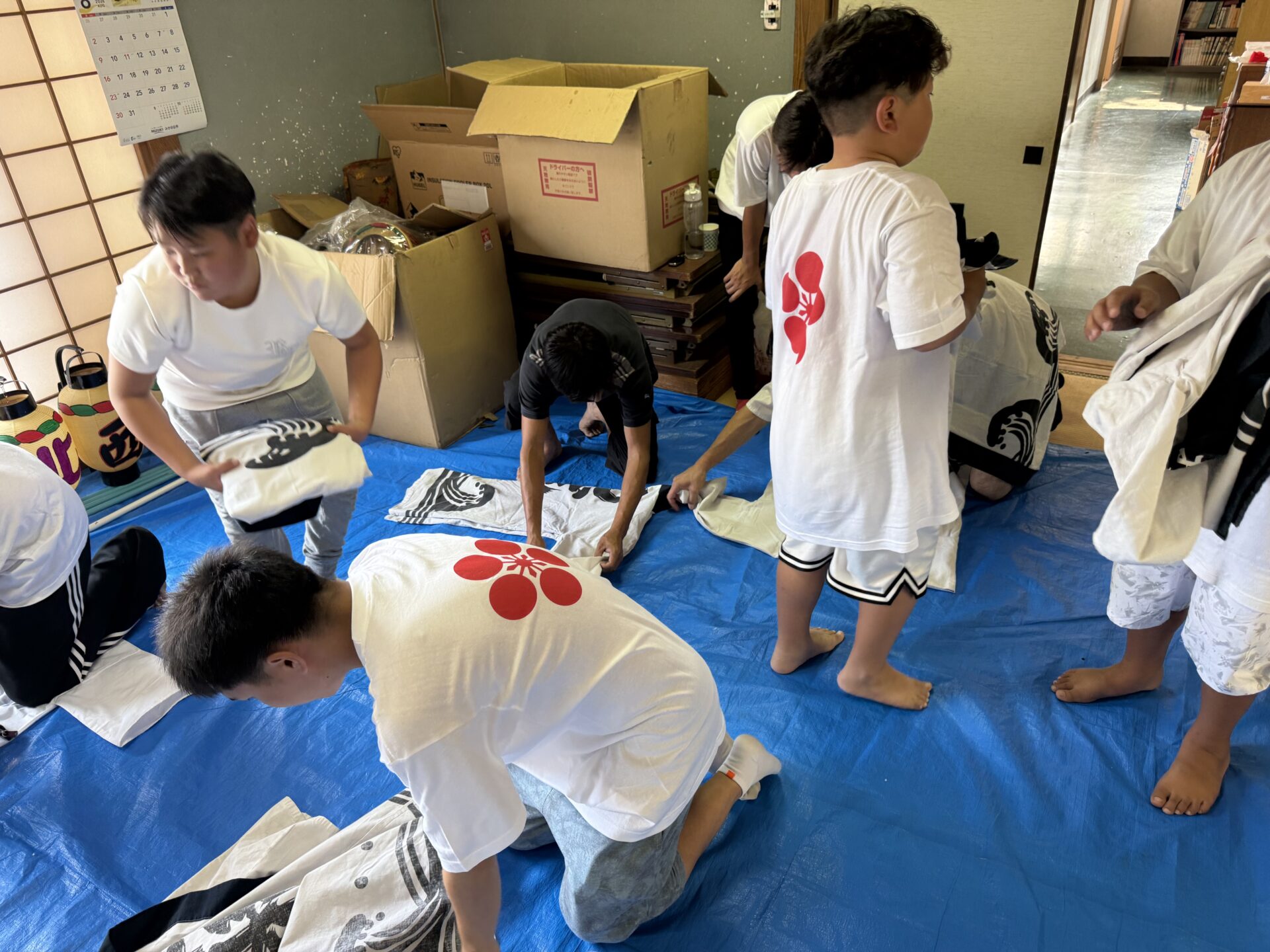 初盆参りを終え法被を丁寧に畳む子どもたち