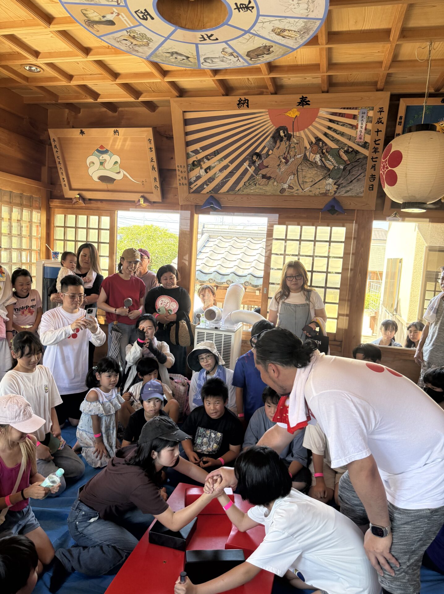 多くの応援を受けながら戦う腕相撲大会参加者